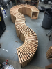 an overview photo of one bench unit, a curvilinear shape of wooden elements, the unit sits in the shop. 