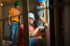 Students attach some drywall underneath a window. Photo: Douglas Levere