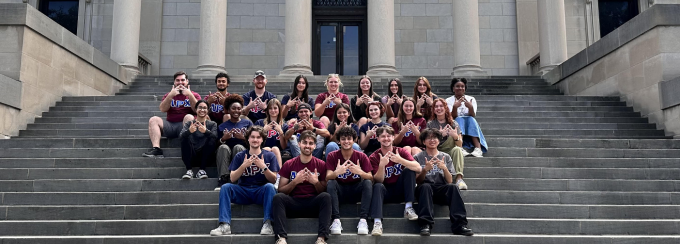 Students sitting outside on the southern stairs of the south campus library. 