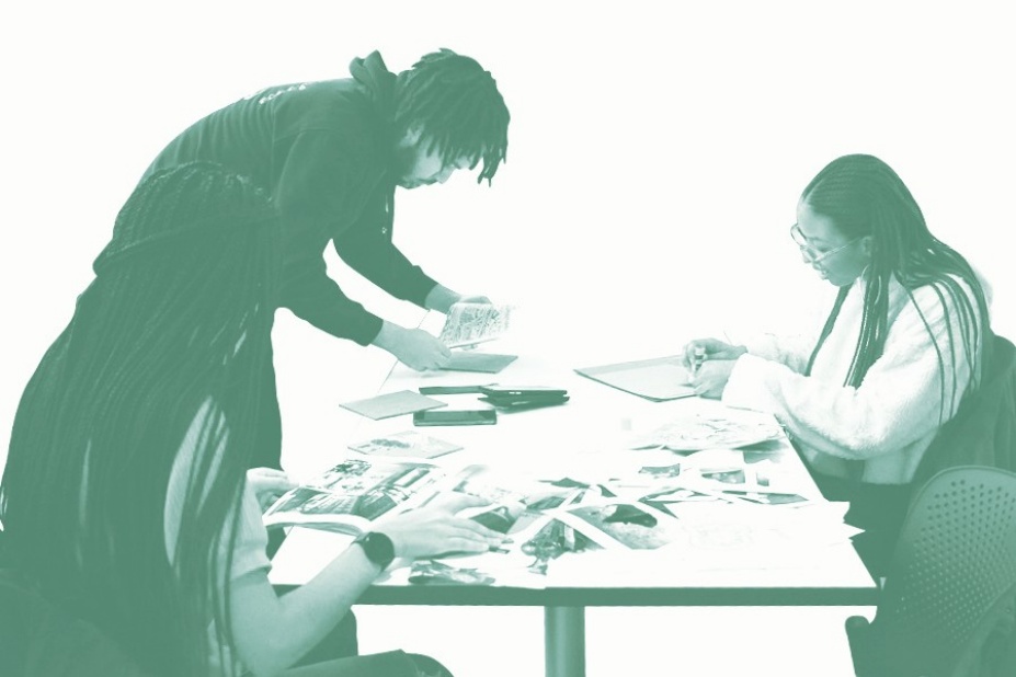 students gathered around the table peruse projects and research. 