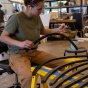Student working on piece of furniture in fabrication workshop. 
