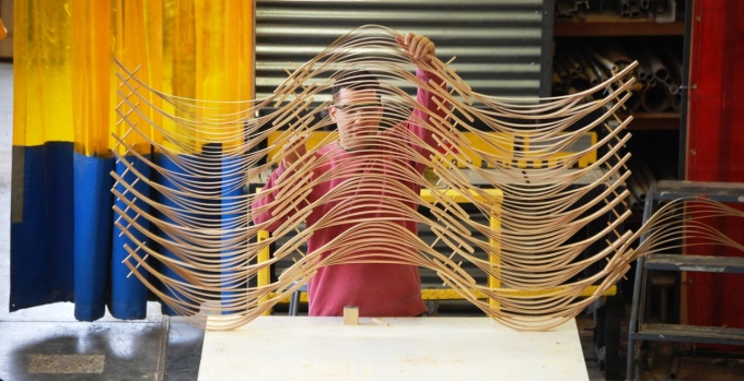 Students holding large, delicate wood screen. 
