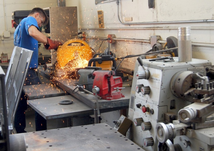 Student using saw in metal shop. 