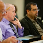 Faculty members engaged in conversation in a school-wide meeting. 