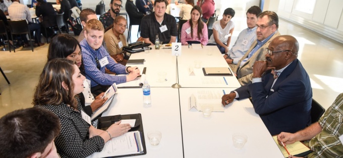group of students with business folios meet with member of the dean's council. 