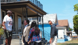 Photograph of students and Professor Data talking with a community resident. 