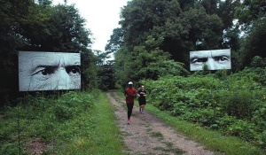 Photograph of joggers running alongside art installations. 
