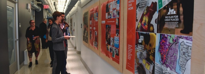 Photograph of guests viewing posters on the wall. 