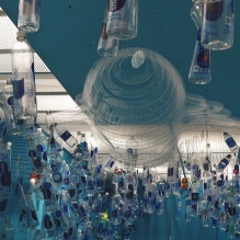 One-thousand plastic beverage containers — and counting — dangle from the ceiling of the last room of “Ocean Cube. 