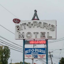 A photo of a neon motel sign on Niagara Falls Boulevard that reads "Bit-o-Paris Motel", with "Vacancy" below. 