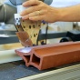 a robotic arm carves terra cotta in the shop at UB. 