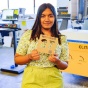 Sriya Radhakrishnan poses with wood invitation. 