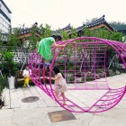 Children playing on curved grid structure. 